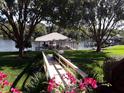 View of the backyard showcasing a covered boat dock and serene waterfront access, surrounded by lush landscaping at 6216 Landings Blvd, Lady Lake, FL 32159