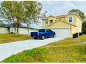 Two-story house with a yard and a driveway, offering curb appeal at 762 Squirrel Ct, Kissimmee, FL 34759