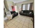 Spacious living room with two black reclining sofas at 762 Squirrel Ct, Kissimmee, FL 34759