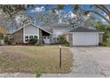 Two-story house with gray siding, brick accents, and a two-car garage at 7798 Snowberry Cir, Orlando, FL 32819