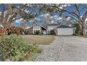 House exterior showcasing a landscaped yard, brick pavers, and mature trees at 7798 Snowberry Cir, Orlando, FL 32819