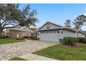 One story home with a paver driveway and mature landscaping at 9033 Laurel Ridge Dr, Mount Dora, FL 32757