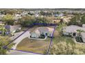 Bird's eye view of a single-story house with a large front yard and driveway at 9320 County Road 125B, Wildwood, FL 34785