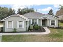 One-story house featuring gray siding, white shutters, and a well-maintained lawn at 9320 County Road 125B, Wildwood, FL 34785