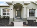 Inviting entryway with a dark green door and arched detail at 9320 County Road 125B, Wildwood, FL 34785