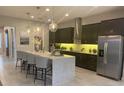 Modern kitchen with dark cabinetry, an island, and stainless steel appliances at 9918 Fiddley Aly, Orlando, FL 32827