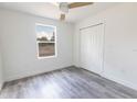 Serene bedroom with wood-look floors, a ceiling fan, and ample natural light from a large window at Lot 42 Indian Estates Cr 423, Lake Panasoffkee, FL 33538