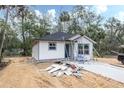 New construction home featuring a light exterior with dark roof and surrounded by beautiful natural landscape at Lot 42 Indian Estates Cr 423, Lake Panasoffkee, FL 33538