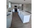 Bright kitchen featuring white cabinets, stainless appliances, quartz countertops, and island at Lot 42 Indian Estates Cr 423, Lake Panasoffkee, FL 33538