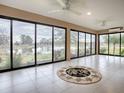 Bright sunroom with tiled floor, large windows overlooking a lake at 5911 Delphina Loop, The Villages, FL 32163