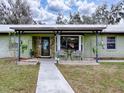 Charming house exterior with a covered porch and a stone accent wall at 1029 Cr 452A, Lake Panasoffkee, FL 33538