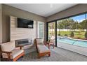 Relaxing poolside patio with fireplace and sliding glass doors at 10377 Silver Maple Ave, Oxford, FL 34484