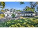 Single-story house featuring a two-car garage and lush green lawn at 1101 Lantana Dr, Eustis, FL 32726