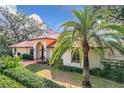 Exterior view of a beautiful house with red tile roof and palm tree at 1130 Elysium Blvd, Mount Dora, FL 32757