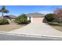 House exterior featuring a tan garage door and landscaping at 1189 Homeland Park St, The Villages, FL 32162