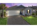 Evening view of house exterior with attractive landscaping at 12213 Se 176Th Loop, Summerfield, FL 34491