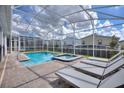 A private screened-in pool with lounge chairs offers a relaxing outdoor retreat at 1257 Challenge Dr, Davenport, FL 33896
