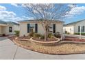 House exterior featuring a curved driveway and stone landscaping at 1410 Conchas Dr, The Villages, FL 32162