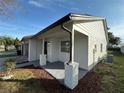 Newly renovated home with white exterior, brown accents, and landscaped yard at 1562 Lawndale Cir, Winter Park, FL 32792