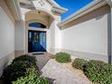 Inviting entryway with a blue door and a brick walkway at 16841 Se 84Th Colerain Cir, The Villages, FL 32162