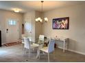 Dining area with glass top table and white chairs near entryway at 16929 Tesla Aly, Winter Garden, FL 34787