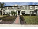 Two-story townhome with gray siding, brown shutters, and a brick walkway at 16929 Tesla Aly, Winter Garden, FL 34787