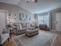 Living room with beige sofa, ottoman, and hardwood floors at 2009 Claudio Ln, The Villages, FL 32159