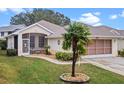 Single-story house with a screened porch and palm tree at 21122 Lionheart Dr, Leesburg, FL 34748