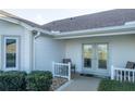 Inviting entrance with double glass doors and charming seating area at 2202 Margarita Dr, The Villages, FL 32159