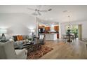 Open living area with hardwood floors and kitchen island at 3257 Kilarny Pl, The Villages, FL 32163