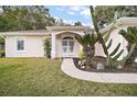 Front entry with a decorative archway and lush landscaping at 34245 Rosa Ln, Fruitland Park, FL 34731