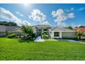 Two-story gray brick home with lush landscaping and a paved walkway at 365 N Spaulding Cv, Lake Mary, FL 32746