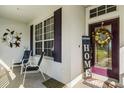 Inviting front porch with purple door, wreath, and comfortable seating at 3898 Beacon Ridge Way, Clermont, FL 34711