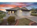 Charming single-story home featuring an attached garage and lovely landscaping at 392 Arbella Loop, The Villages, FL 32162