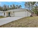 New construction home showcasing a spacious driveway and landscaping at 40210 Orange Cir, Lady Lake, FL 32159