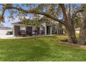 Gray house exterior with large oak tree and manicured lawn at 5055 County Road 125 # B1, Wildwood, FL 34785