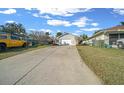 Long driveway leads to a well-maintained single-story home with an attached garage at 7 Ginger Cir, Leesburg, FL 34748