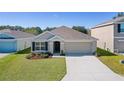 One-story house with a two-car garage and landscaping, aerial view at 8661 Triumph Cir, Wildwood, FL 34785