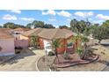 Charming single-story home with a well-manicured yard featuring lush tropical landscaping and a paved driveway at 878 Oviedo Rd, The Villages, FL 32159