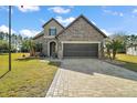 Two-story home with stone accents and a three-car garage at 9277 Sw 70Th Loop, Ocala, FL 34481