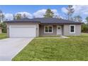 New construction home with gray siding, white garage door, and neat lawn at 1 Malauka Pass Ct, Ocklawaha, FL 32179