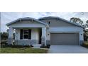 One-story home with gray siding, stone accents, and a two-car garage at 10161 Spring Lake Dr, Clermont, FL 34711