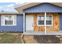 Inviting front porch with stone facade and white door at 10830 Anna Belle Ave, Leesburg, FL 34788