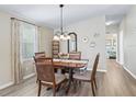 Dining area with a wood table and chairs, hardwood floors and view of living room at 1210 Tarpon Ln, The Villages, FL 32159