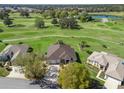 Stunning aerial view of home and golf course with mature trees and serene water feature at 12886 Se 97Th Terrace Rd, Summerfield, FL 34491