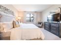 Bright bedroom featuring a large window with water views, complemented by stylish decor at 16300 County Road 455 # 414, Bella Collina, FL 34756