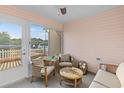 Enclosed porch with neutral color scheme and cozy seating arrangement at 17461 Se 93Rd Retford Ter, The Villages, FL 32162
