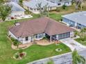 Single-story home with brown roof, spacious yard, and driveway at 21524 Queen Anne Ct, Leesburg, FL 34748