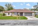 Single-story house with brown roof, screened porch, and driveway at 21524 Queen Anne Ct, Leesburg, FL 34748