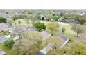 Aerial view of homes in a lush golf course community with mature trees and green fairways at 2209 Stonebridge Way, Clermont, FL 34711